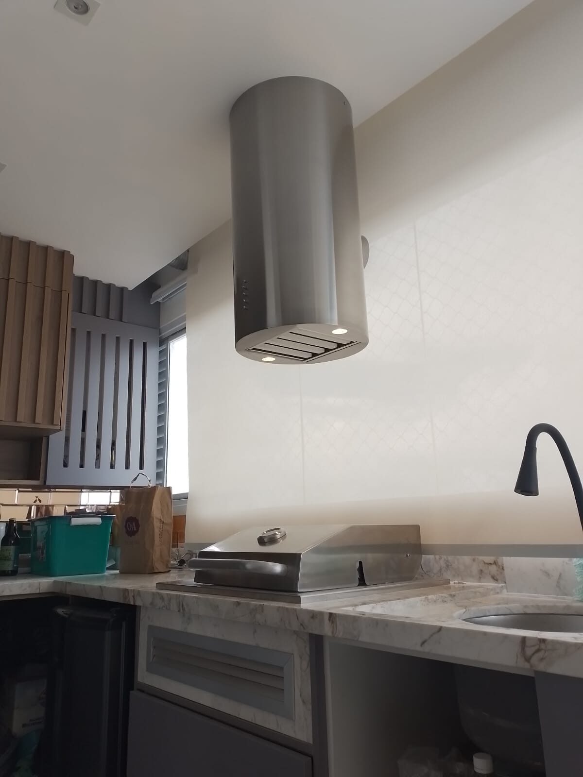 Detalhe do acabamento em aço inox de coifa tubular sob medida