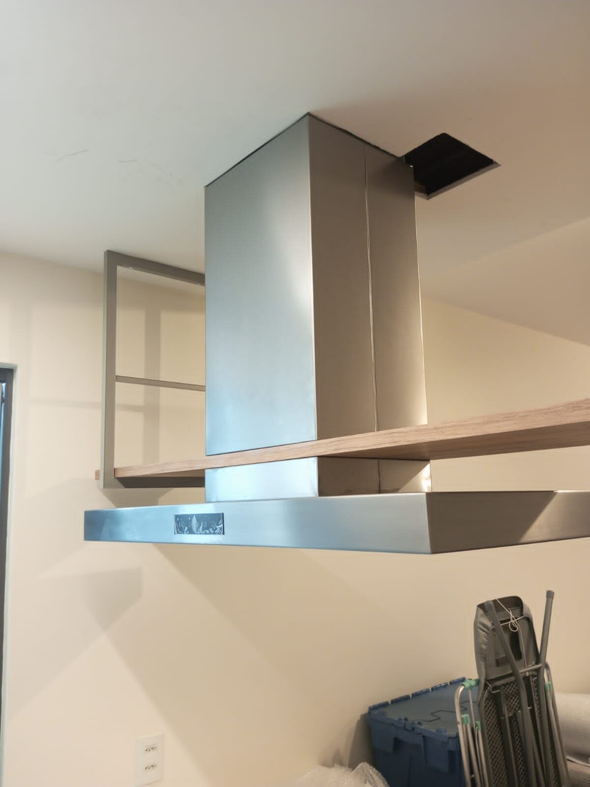 Vista lateral de coifa personalizada em aço inox instalada sobre ilha